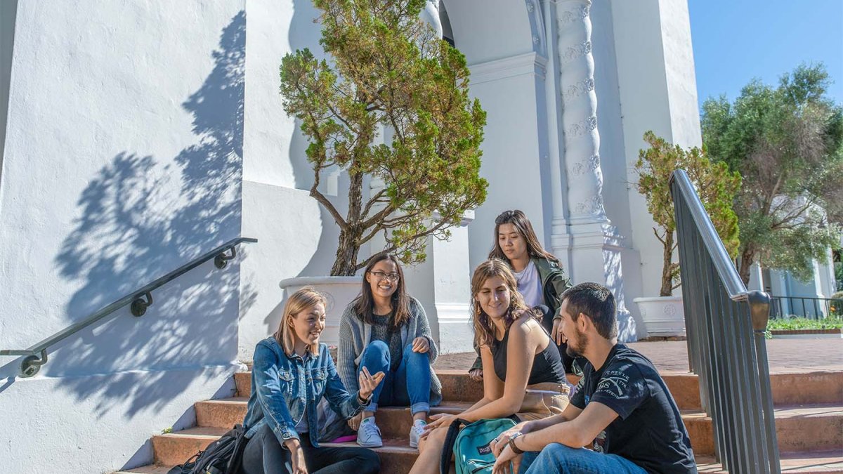 students sit on the steps of school chapel