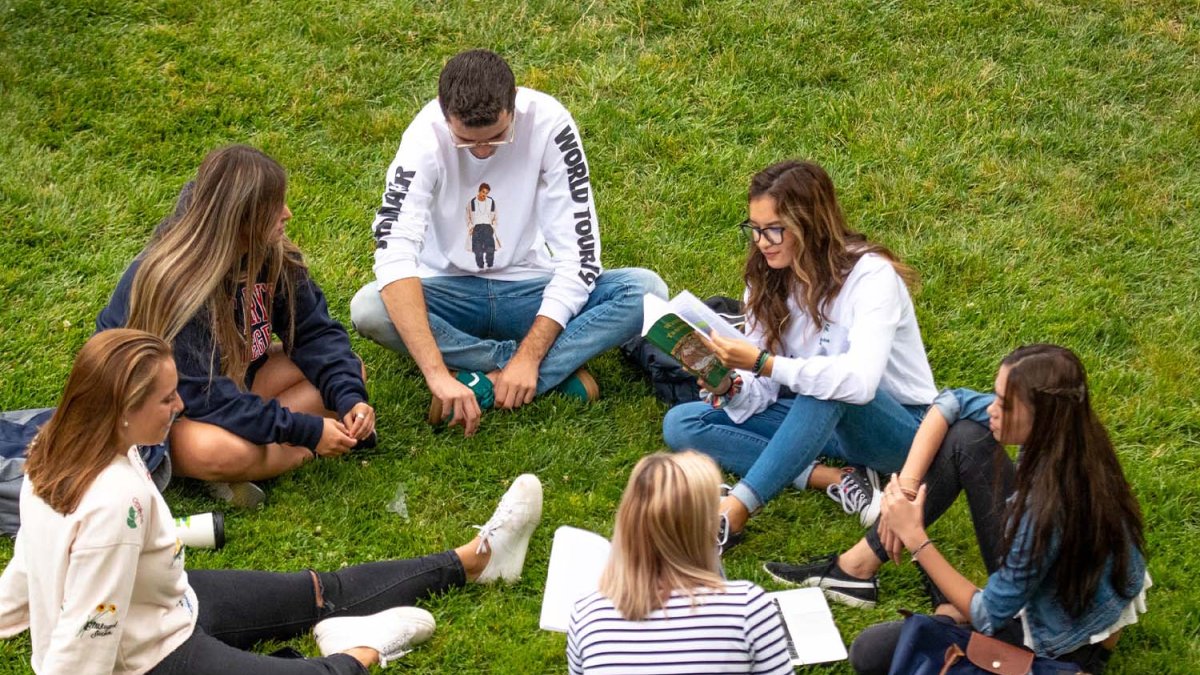 Students sit in circle outside
