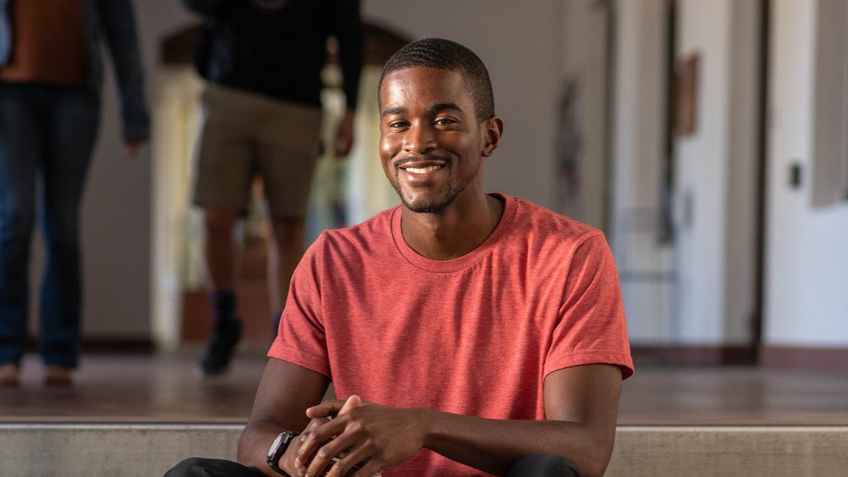 Student sits on steps of building