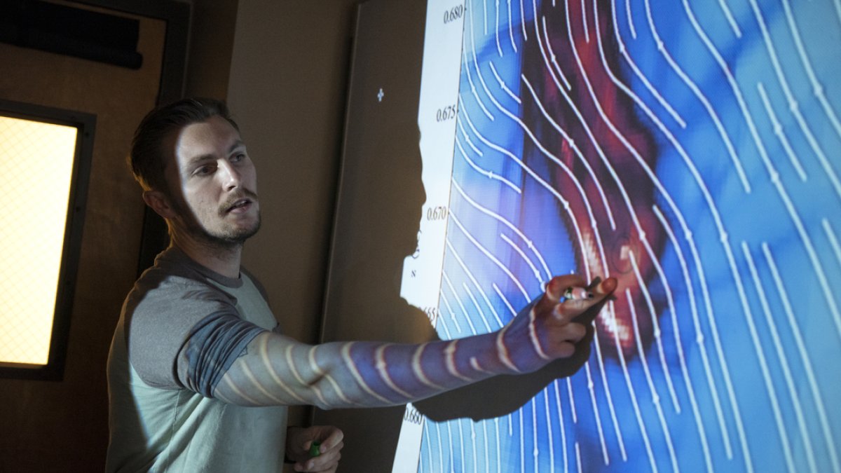 A student pointing data on a white board