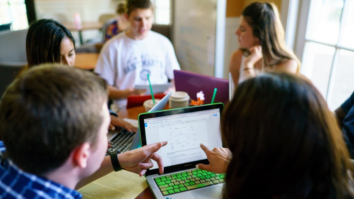 A Writing Circle Facilitator and a writer looking at a laptop screen.