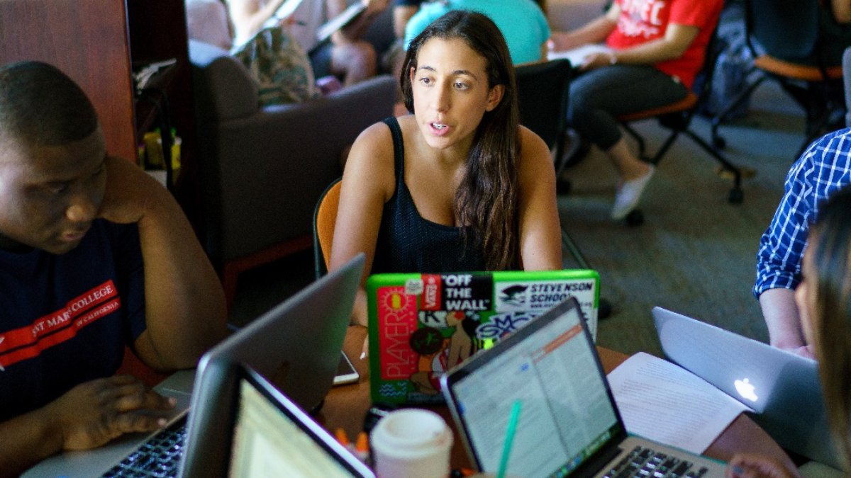 Students and a facilitator in a Writing Circle in a busy Writing Center.