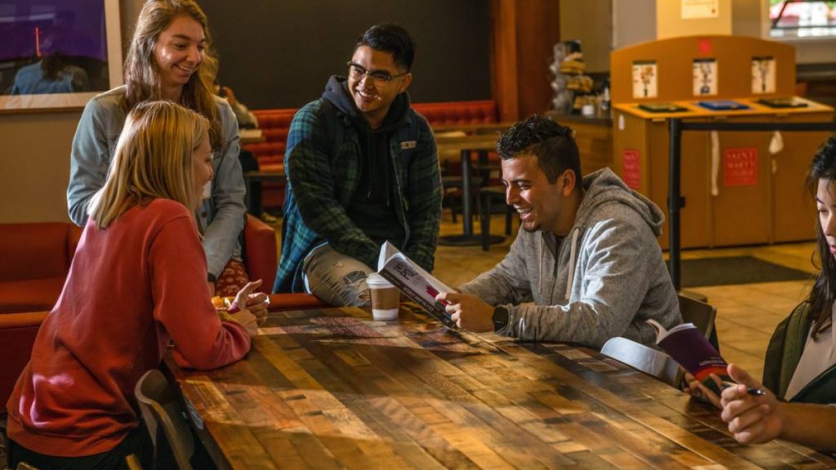 three students gathered by table