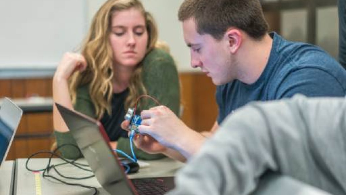 engineering students looking at laptop