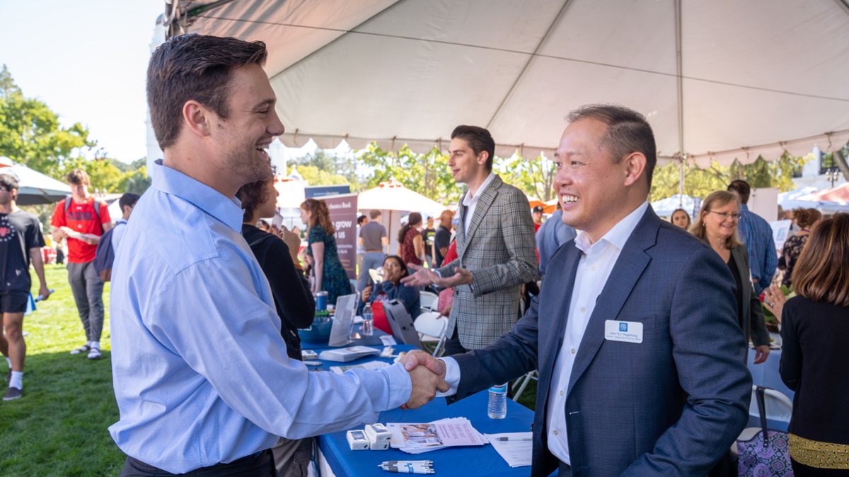 A student and potential employer shaking hands during the career fair