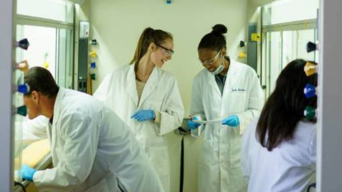 four students doing a lab in lab gear