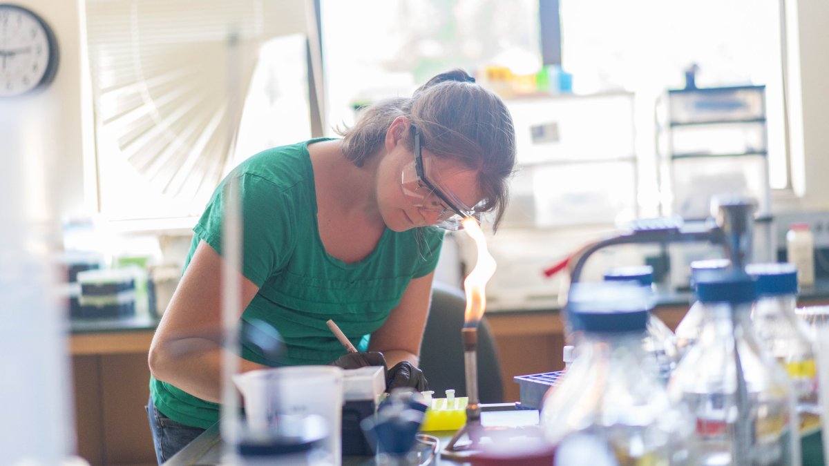 Student in a chemistry lab writing down notes