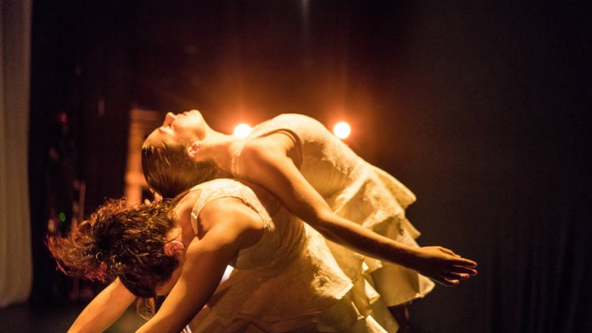 Two female dancers back-to-back on stage