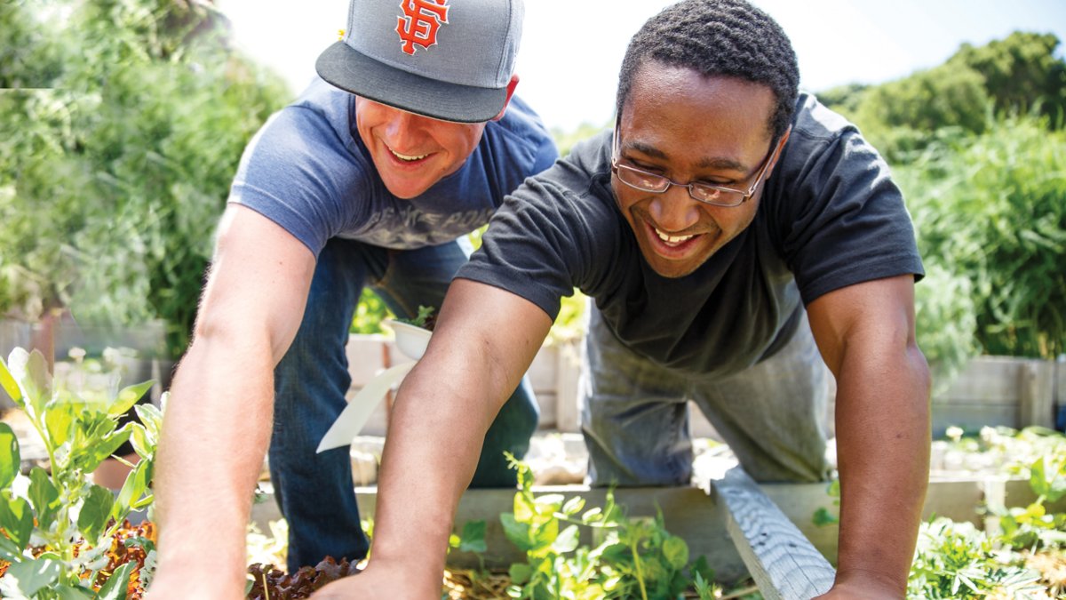 Students reaching for a strawberry laughing