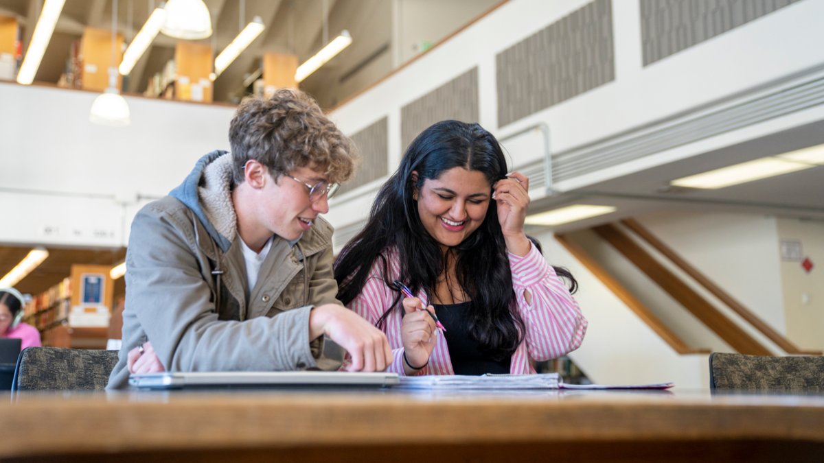 Students in the library smiling and laughing