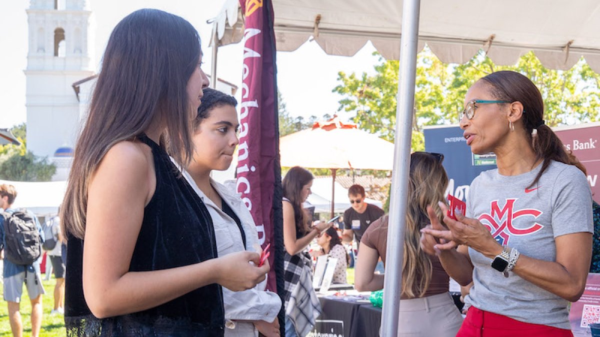 Two students talk with a recruiter at Career Fair