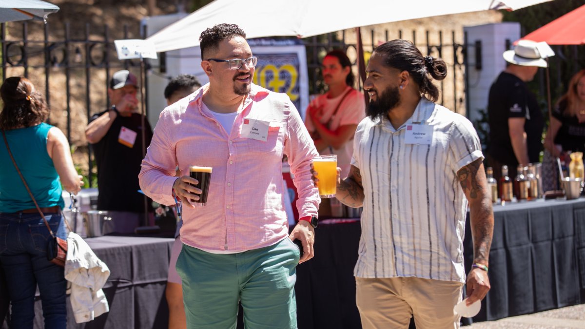Two young men hold beers