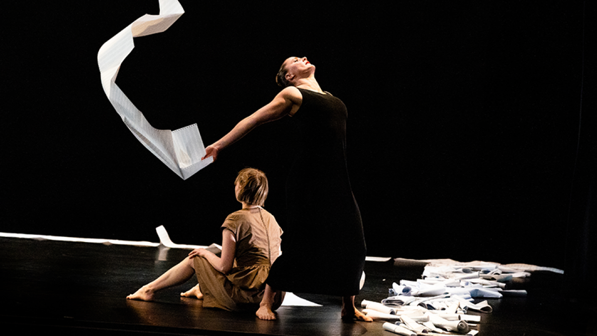 Two dancers with paper on stage