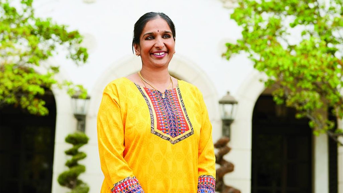 dr. vidya chandrasekaran in a yellow dress in front of brousseau hall