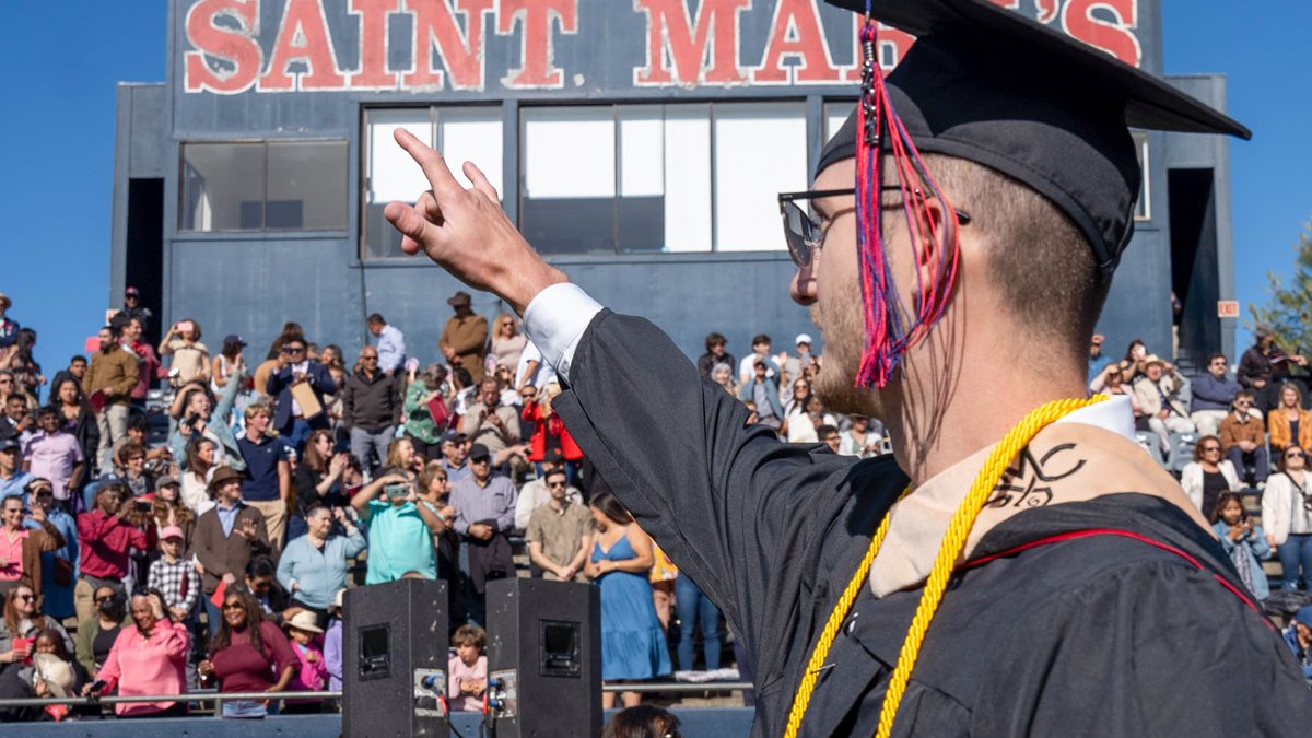 saint mary's student point to family at master's graduation