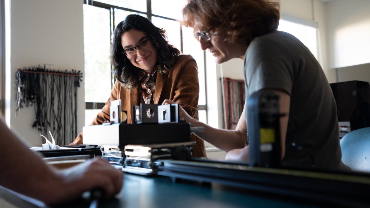 Two women look at a lab desk