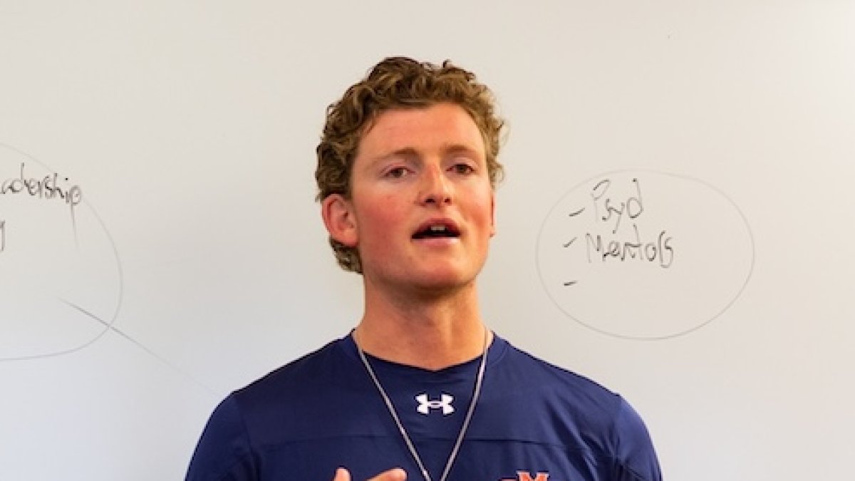 SMC Men's Tennis player in front of white board in class on leadership