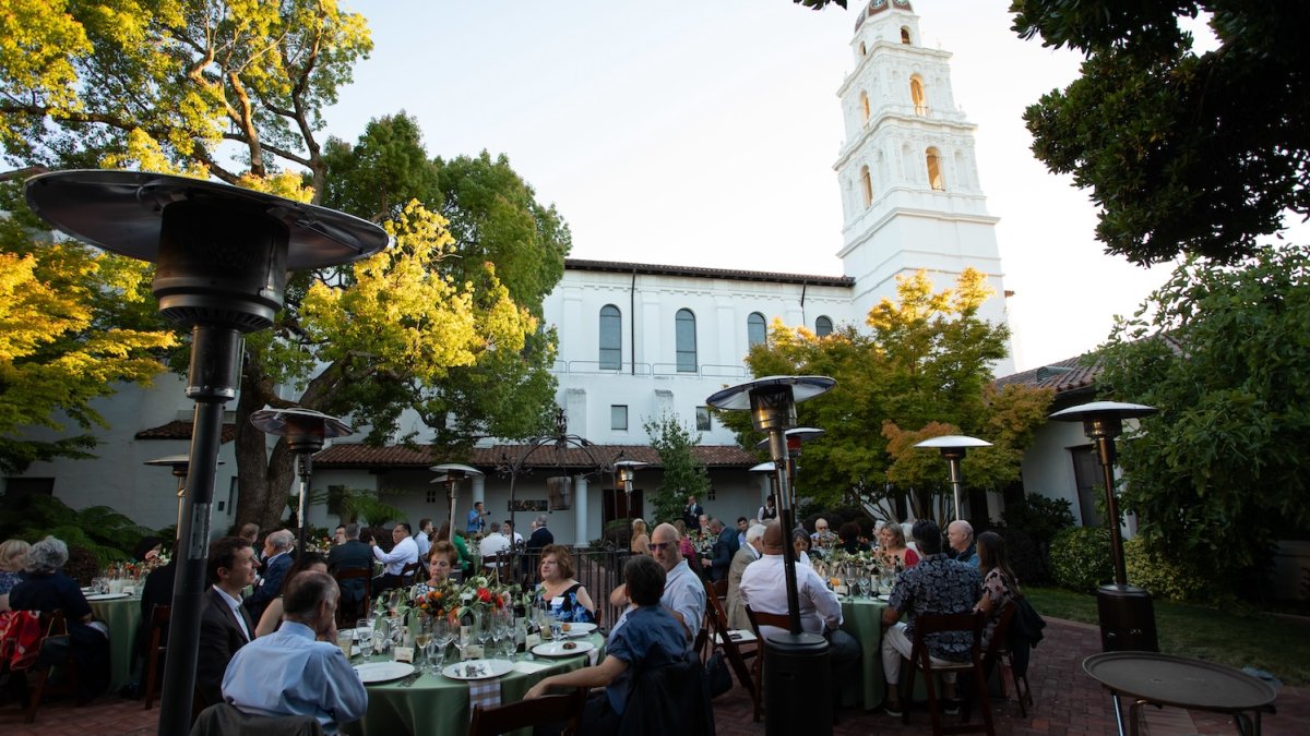 Seated dinner with fine florals in a courtyard under the chapel tower