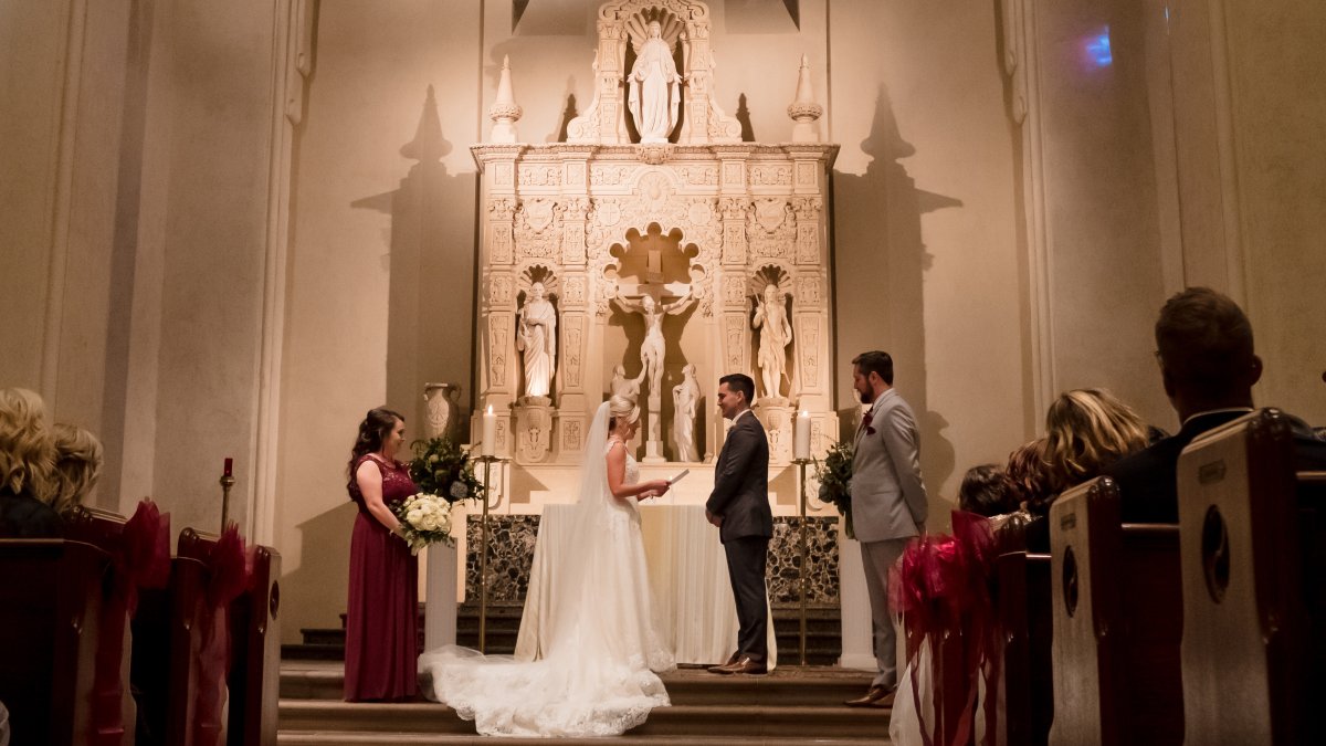 A wedding couple stands in the front of the altar of the SMC Chapel sharing their vows.